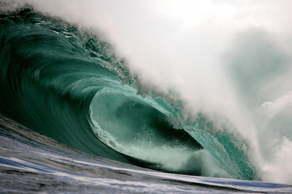 Close-up of a powerful wave curling over itself in the ocean.