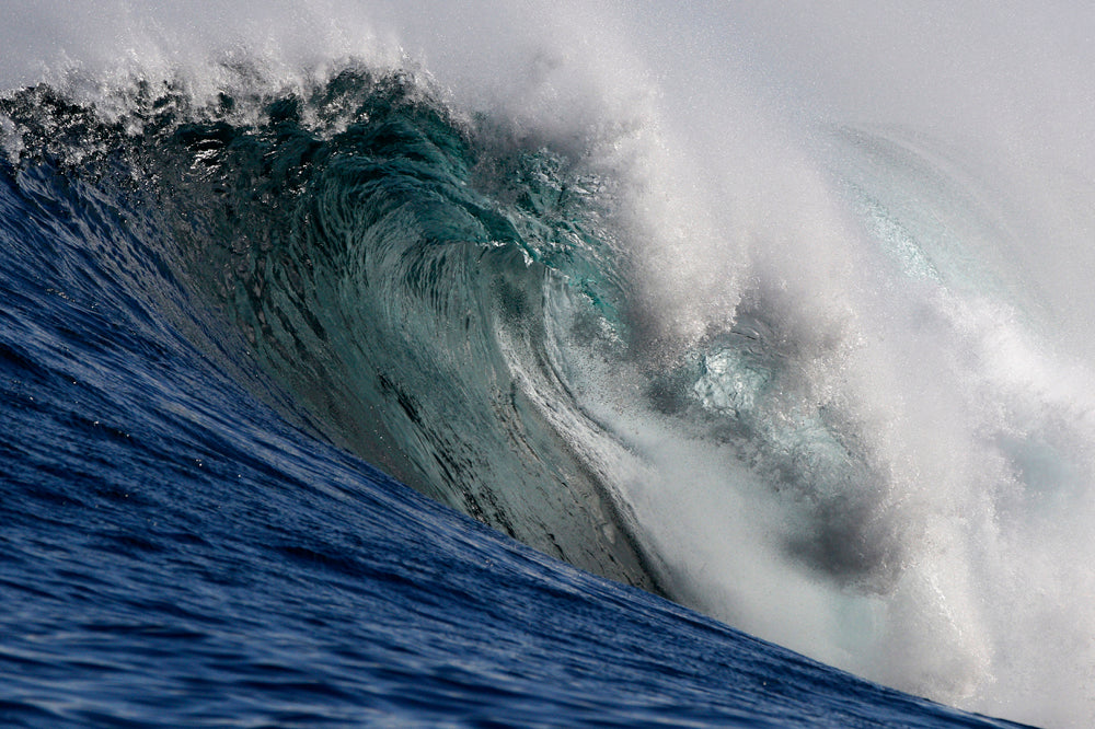 Large ocean wave with white foam curling over itself