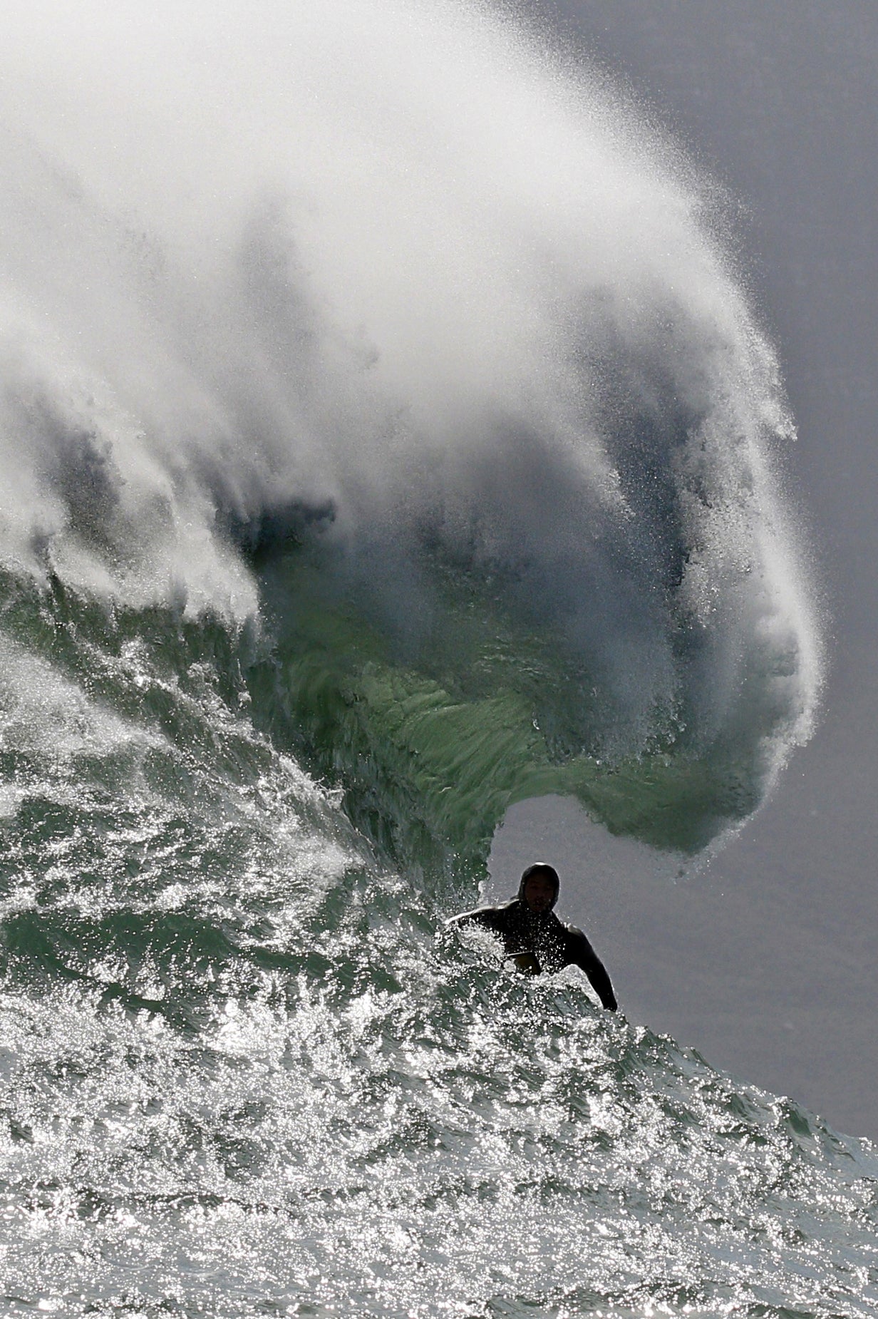 Surfer riding a large wave with a dramatic splash.